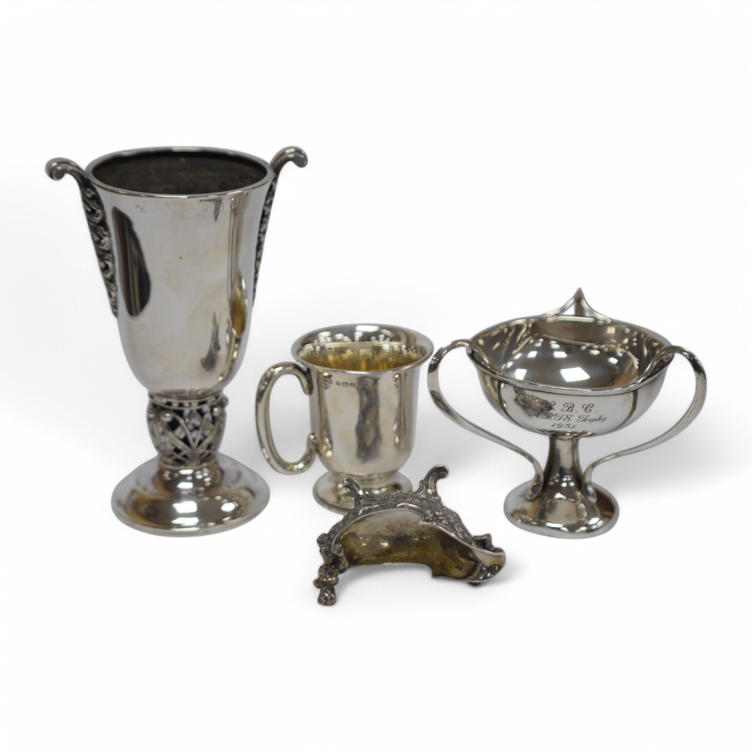 A George V silver spill vase, with pierced handles and stem, maker's mark rubbed, Birmingham, 1930, 16.6cm, together with a small silver tri-handled pedestal bowl, a small silver mug and Hanau white metal boat shaped sal